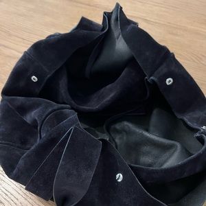 A dark suede navy Theory handbag.